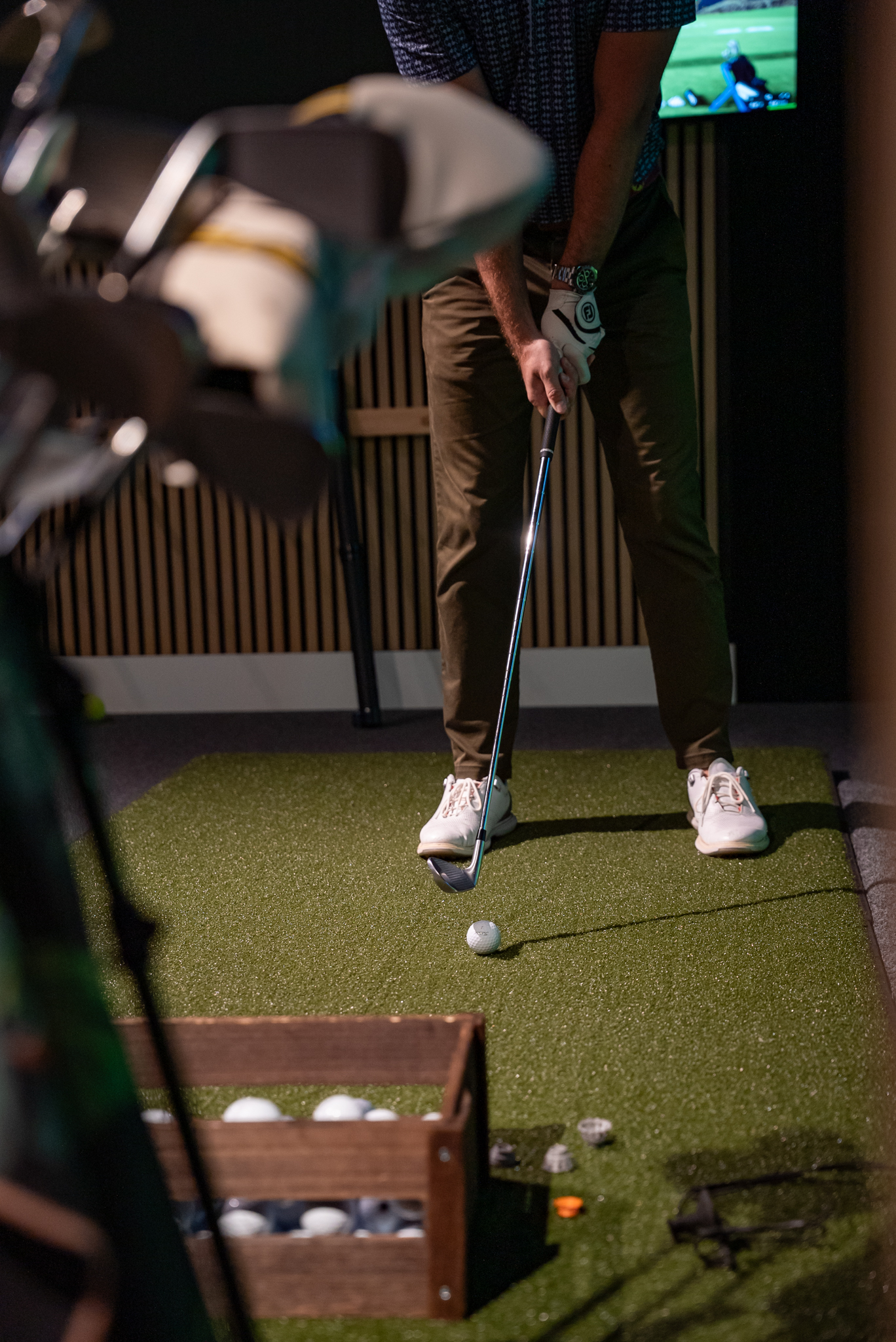 Golfer addressing ball on simulator hitting mat